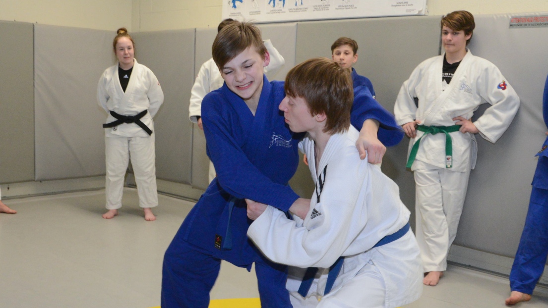 Audrey Dion (en arrière à gauche) observant ses judokas sur le tatami.