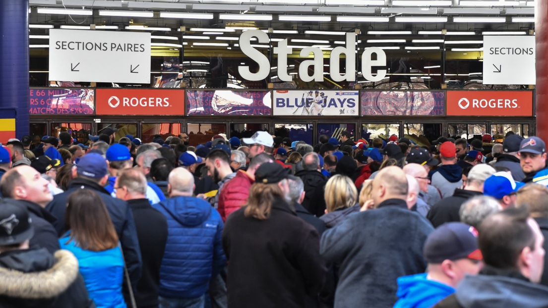 Des partisans à l'entrée du Stade olympique avant un match préparatoire des Blue Jays de Toronto.