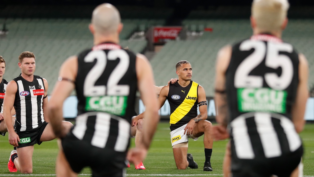 Des athlètes déposent un genou au sol avant un match de football australien