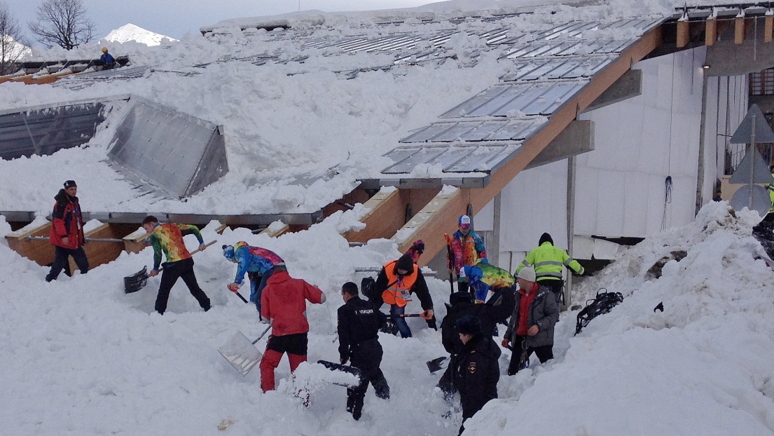 Des ouvriers qui déneigent le centre de bobsleigh à Sotchi